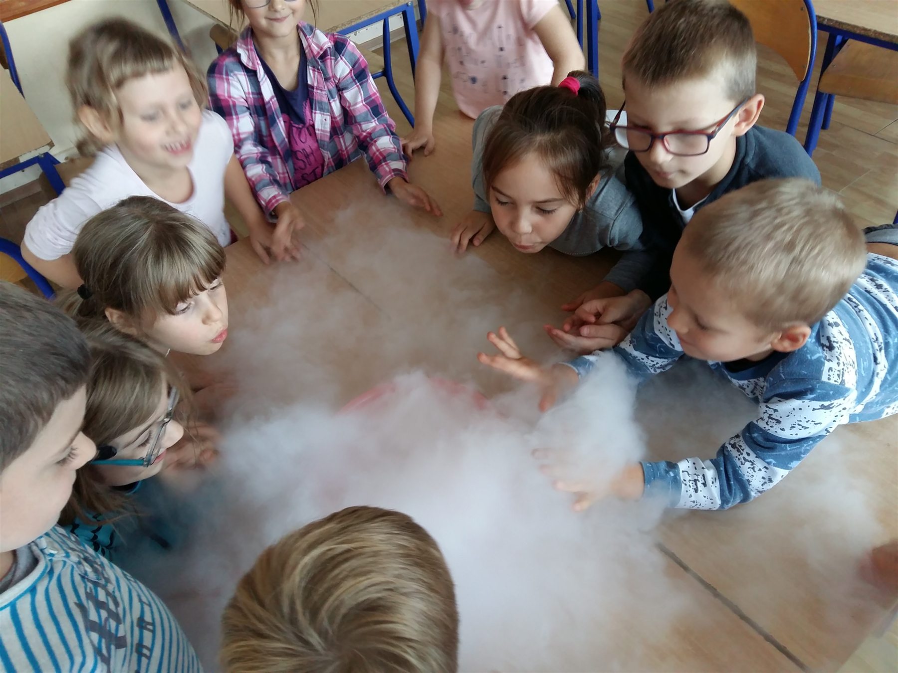 Dzieci obserwujące doświadczenie z suchym lodem